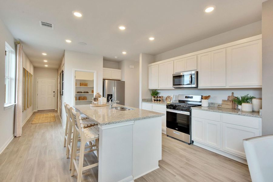 A well-appointed kitchen showcasing an inviting island with seating and sleek stainless steel appliances. A well-appointed kitchen showcasing an inviting island with seating and sleek stainless steel appliances.