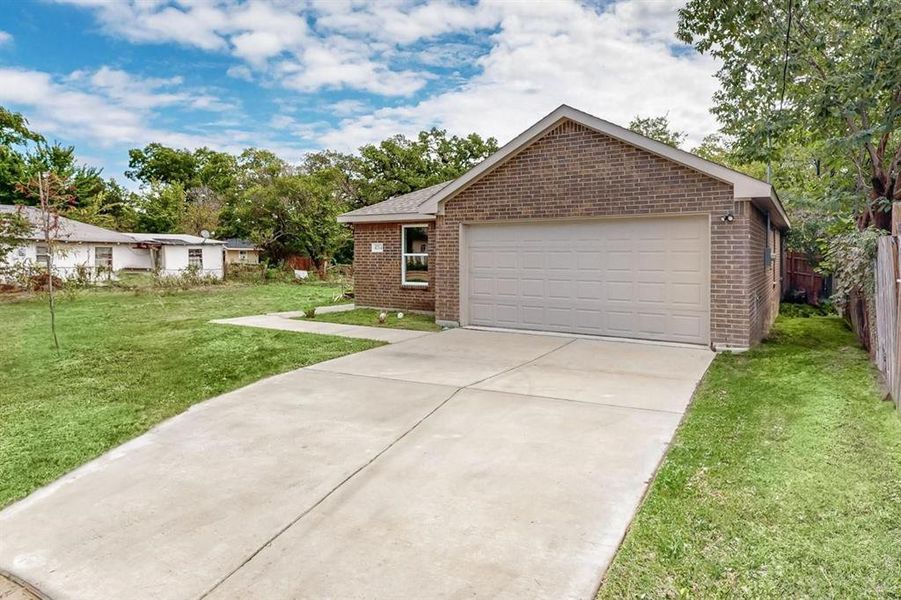 Single story home with a garage and a front yard