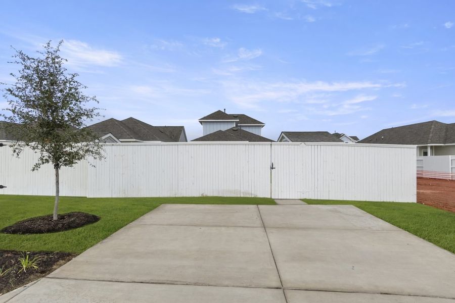 Image of back cement driveway with a white fence Image of back cement driveway with a white fence