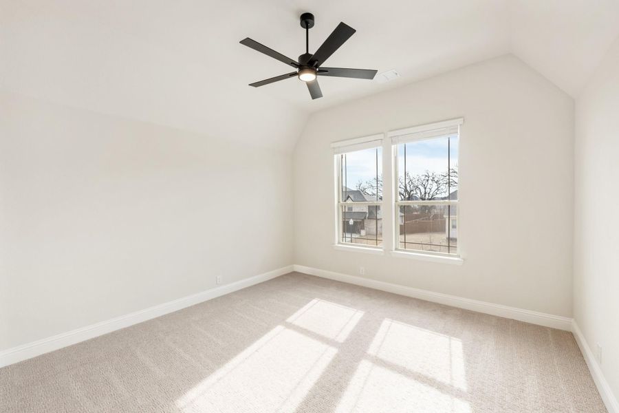Empty bedroom with vaulted ceiling, black ceiling fan, carpet flooring, and double windows