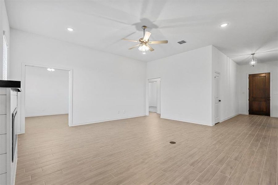 Unfurnished living room featuring light wood-type flooring and ceiling fan