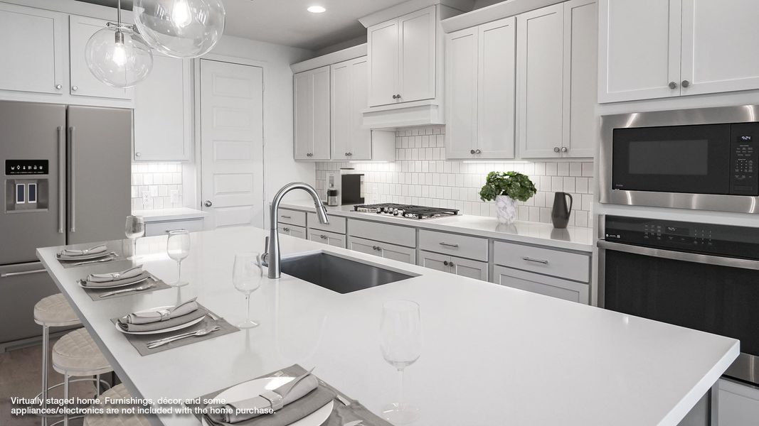 Kitchen featuring a kitchen breakfast bar, appliances with stainless steel finishes, backsplash, hanging light fixtures, and white cabinets Kitchen featuring a kitchen breakfast bar, appliances with stainless steel finishes, backsplash, hanging light fixtures, and white cabinets