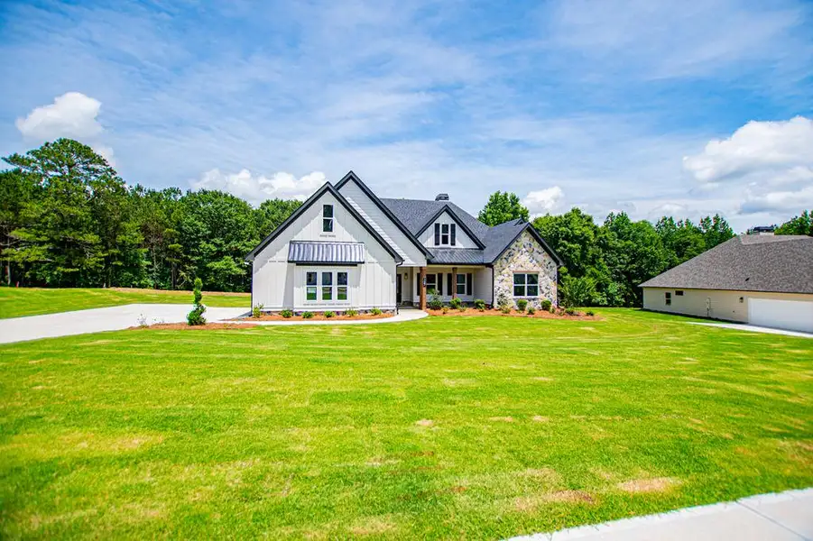 Front exterior of a new home in WOODMONT RESERVE, Roopville, GA, highlighting curb appeal (Image 27).