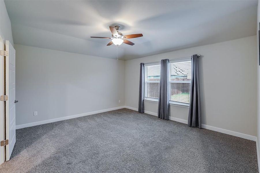 Unfurnished room with light colored carpet and ceiling fan Unfurnished room with light colored carpet and ceiling fan