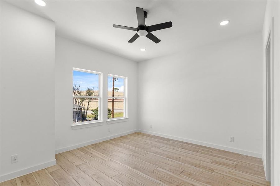 Secondary bedroom featuring light wood-type flooring, ceiling fan, baseboards, and recessed lighting