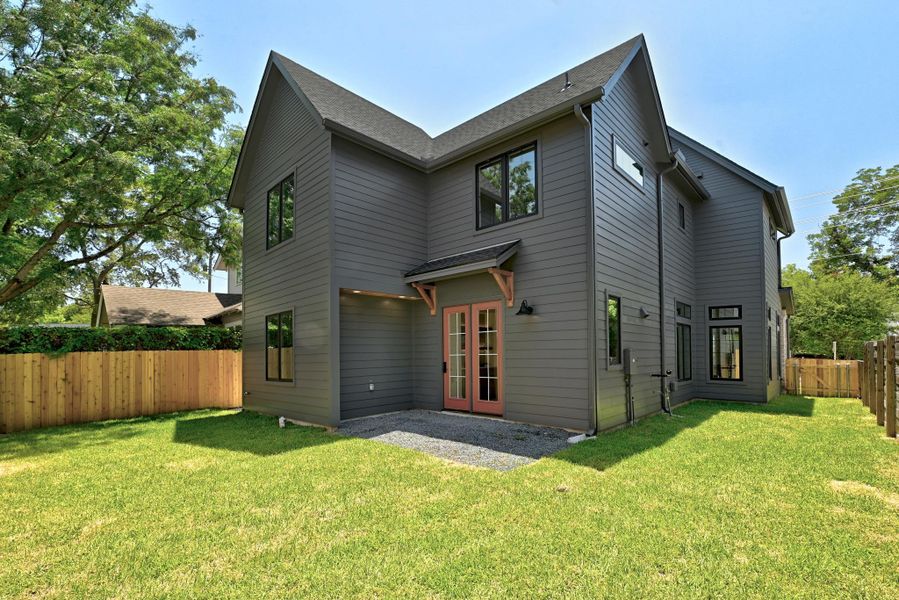 A private, fenced backyard offers lush green space and access to the modern home's exterior. A private, fenced backyard offers lush green space and access to the modern home's exterior.