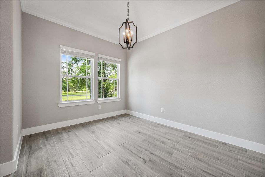 Dining room with high ceilings, crown molding and large windows.