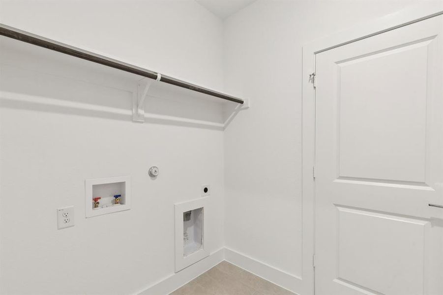 Laundry room with hookup for a gas dryer, washer hookup, electric dryer hookup, and light tile patterned floors Laundry room with hookup for a gas dryer, washer hookup, electric dryer hookup, and light tile patterned floors