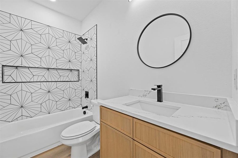 Full bathroom with tiled shower / bath combo, wood-type flooring, vanity, and toilet