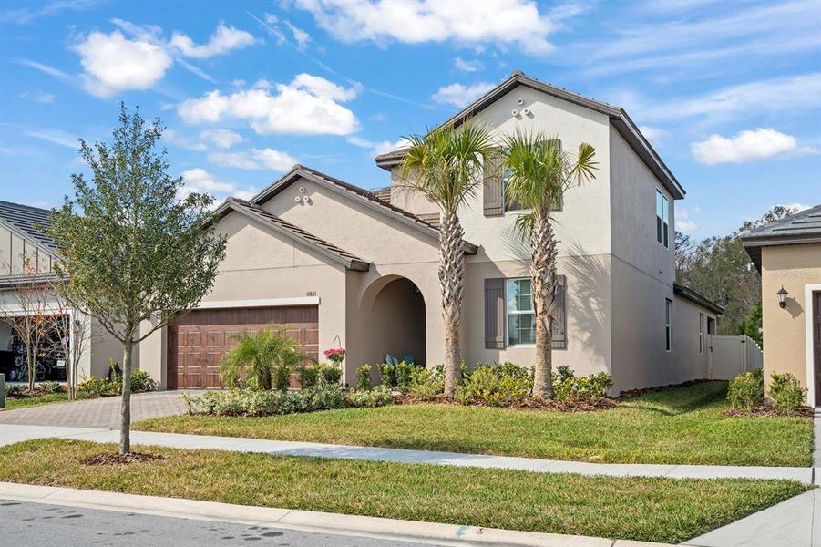 Front exterior of a new home in Angeline Active Adult: Active Adult Manors, Land O' Lakes, FL, highlighting curb appeal (Image 1). Front exterior of a new home in Angeline Active Adult: Active Adult Manors, Land O' Lakes, FL, highlighting curb appeal (Image 1).