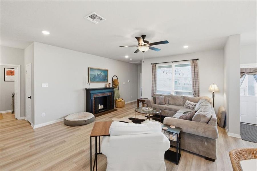 Living room featuring a ceiling fan, light wood-type flooring, and recessed lighting Living room featuring a ceiling fan, light wood-type flooring, and recessed lighting