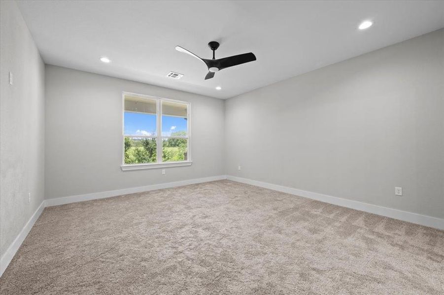 Carpeted spare room featuring ceiling fan and recessed lighting