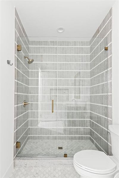 Full bathroom with toilet and a shower stall