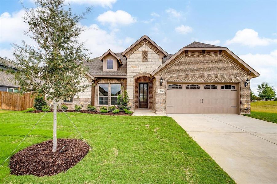 View of front of house featuring a front yard and a garage