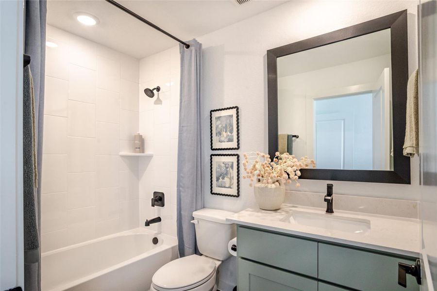 This bathroom features a modern design with a sleek white bathtub and black fixtures. It includes a stylish vanity with a large framed mirror. This bathroom features a modern design with a sleek white bathtub and black fixtures. It includes a stylish vanity with a large framed mirror.