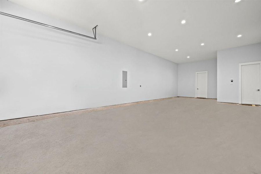 Oversized garage with high ceilings, recessed lighting, and plenty of room for vehicles, storage, or a workshop setup. A clean slate ready to fit your needs.