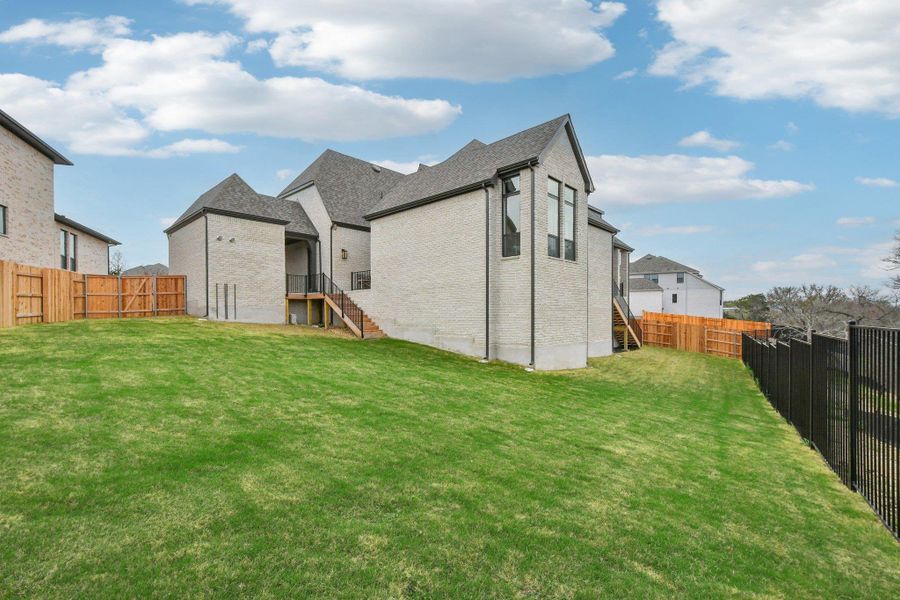 The property features a spacious lawn, a light-colored brick exterior, and a dark-shingled roof The property features a spacious lawn, a light-colored brick exterior, and a dark-shingled roof
