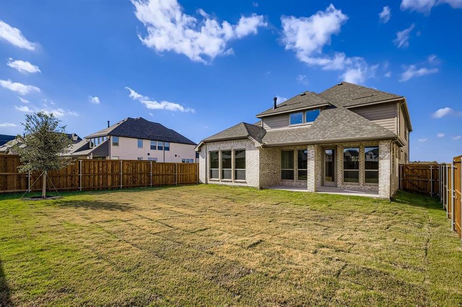 Back of house featuring a patio, a fenced backyard, brick siding, and roof with shingles Back of house featuring a patio, a fenced backyard, brick siding, and roof with shingles