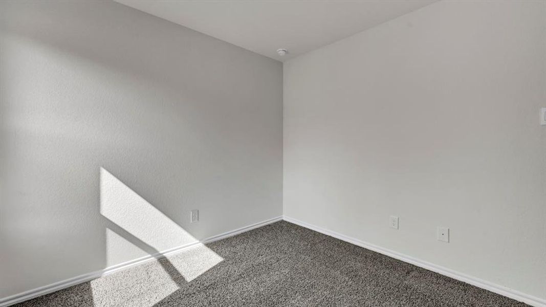 Room featuring light gray wall paint, dark gray carpeting, and white baseboards
