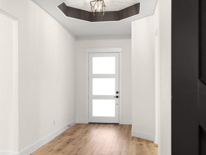 Entryway featuring wood finished floors and suspended lighting