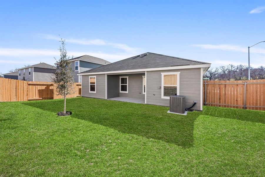 Rear view of house with a lawn, a patio area, and cooling unit