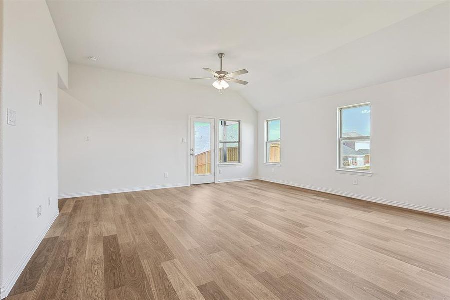 Unfurnished room featuring light hardwood / wood-style floors, vaulted ceiling, and ceiling fan