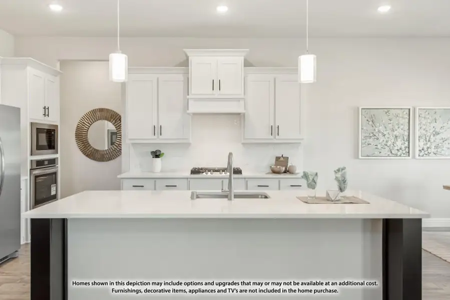 White kitchen with large island, pendant lights, white cabinets, and stainless steel appliances