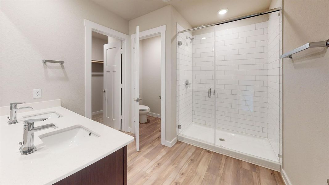 A well-appointed bathroom features a double vanity and a glass-enclosed shower with subway tile. A well-appointed bathroom features a double vanity and a glass-enclosed shower with subway tile.