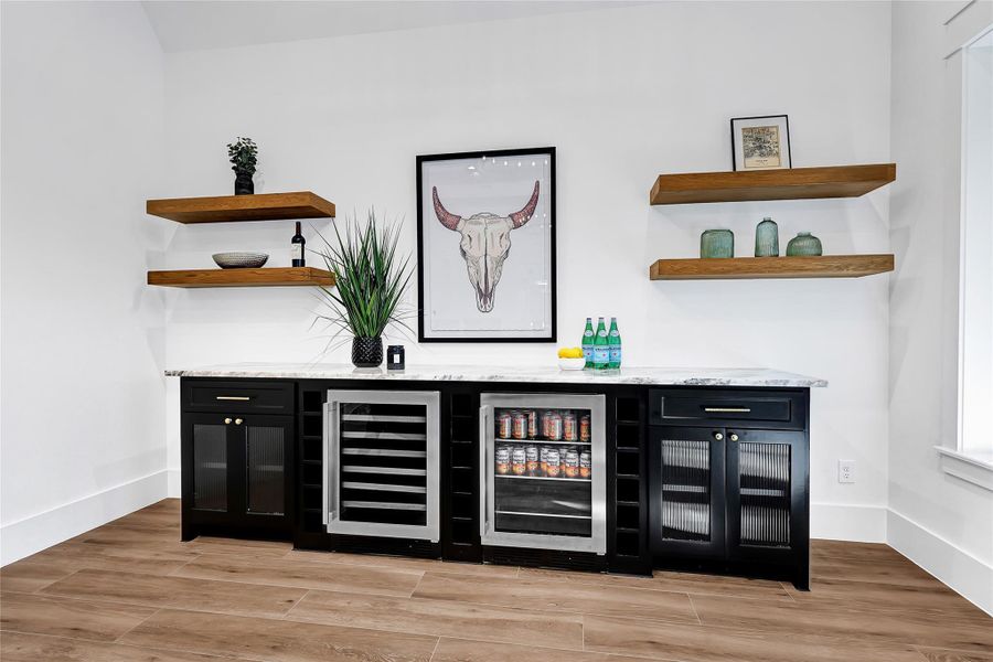Game room with custom built-ins and mini fridge and wine cooler