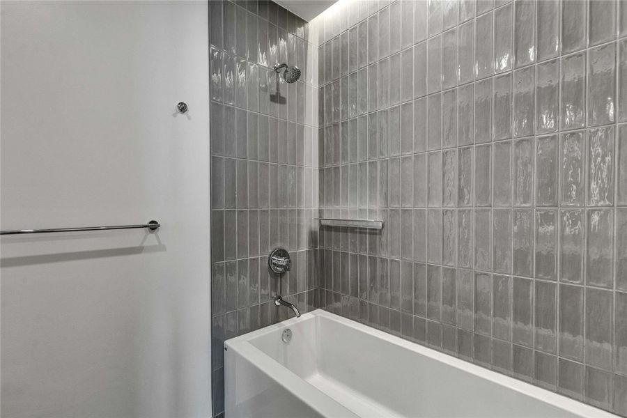 Gleaming vertical tiles frame a deep soaking tub in this modern bathroom design. Gleaming vertical tiles frame a deep soaking tub in this modern bathroom design.