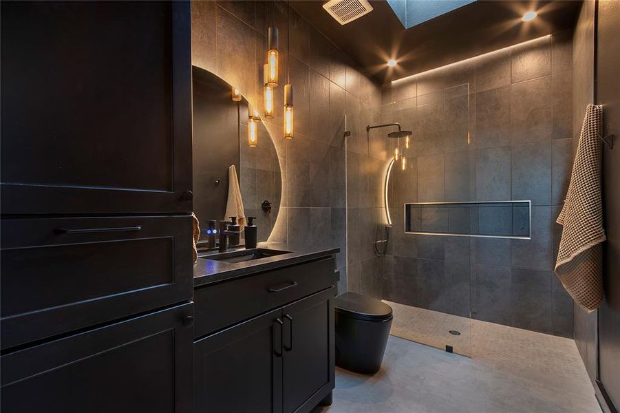 Bathroom with vanity, walk in shower, and a skylight Bathroom with vanity, walk in shower, and a skylight