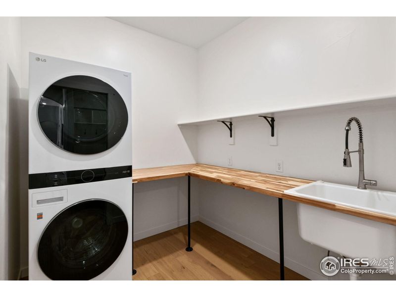 Main level laundry room is just outside the primary suite and provides ample counter and shelf space.