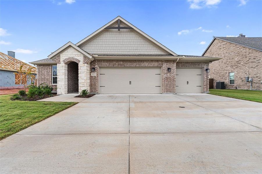 View of front of house with brick siding, driveway, an attached garage, and a front lawn View of front of house with brick siding, driveway, an attached garage, and a front lawn