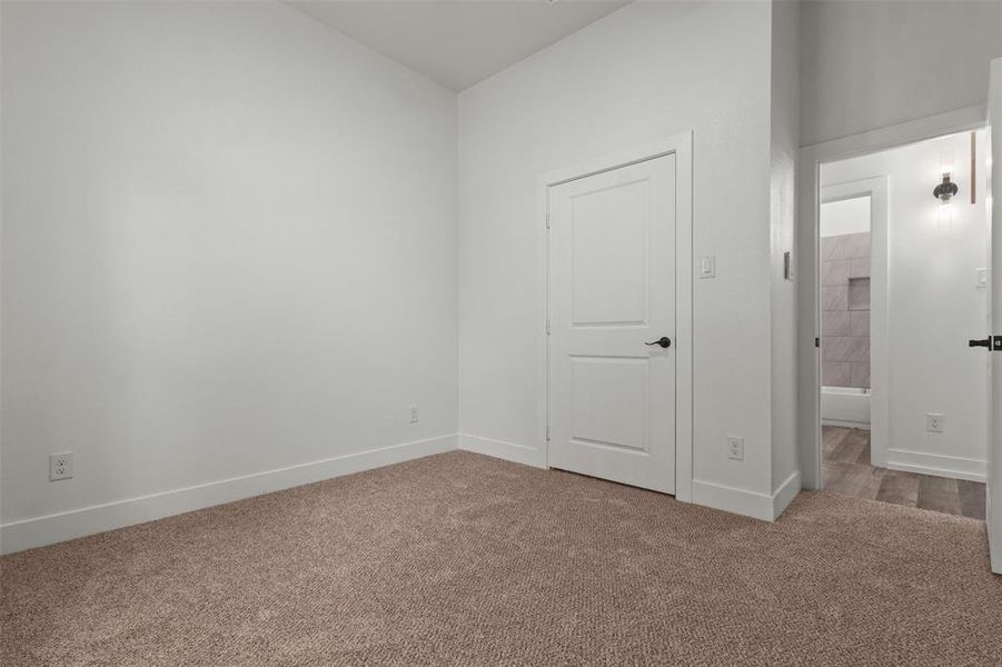 Interior room featuring light-colored walls and soft brown carpeting