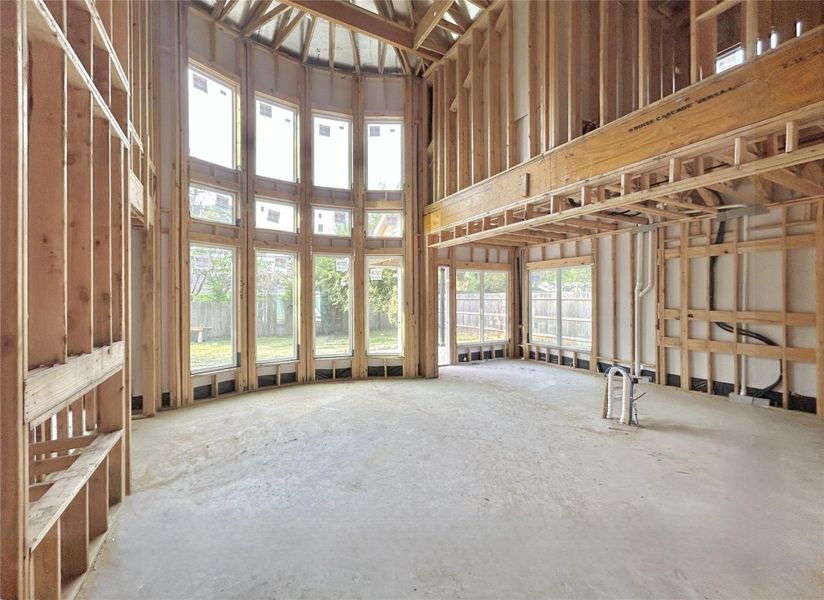 Living Area That Features High Ceilings, Natural Light, and An Electric Fireplace. Construction Photo as of 3/4/2026