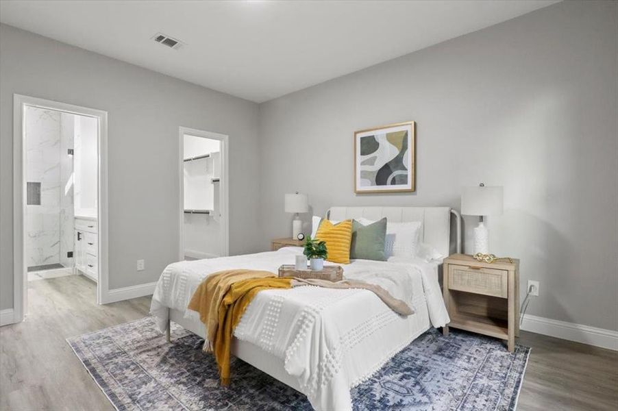 Bedroom with wood-type flooring and connected bathroom