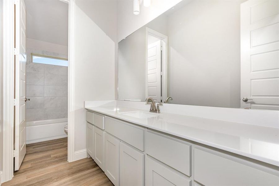 Bathroom featuring vanity, light wood-type flooring, and tub / shower combination