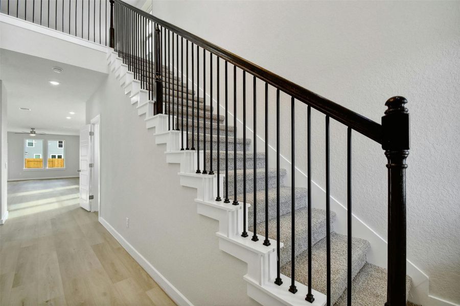 Stairs with ceiling fan and wood-type flooring