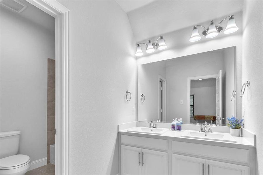 Bathroom with ensuite bath, a sink, toilet, and tile patterned floors