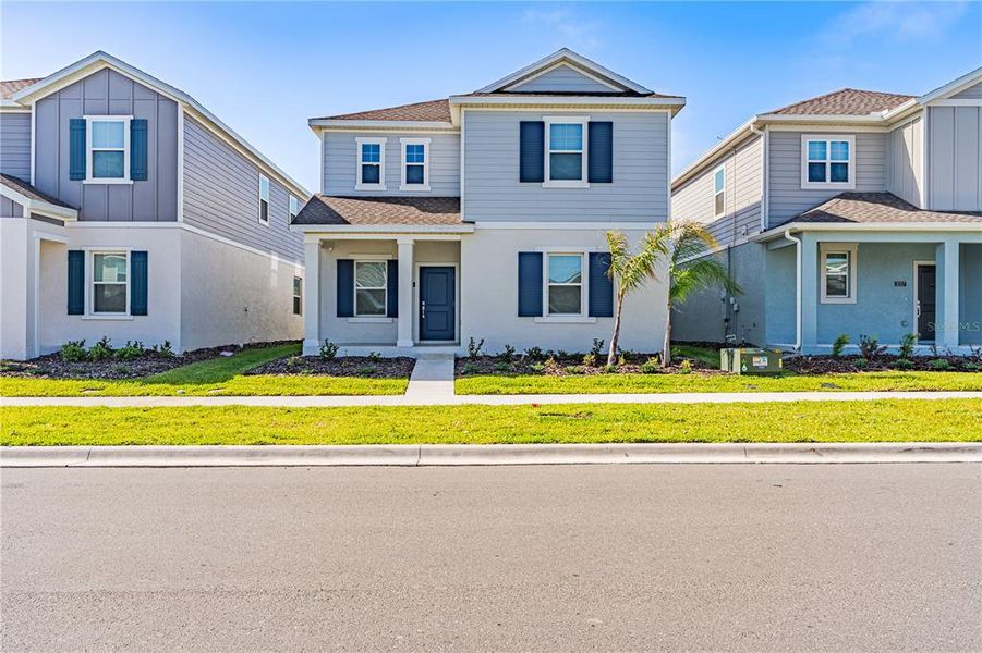 Front exterior of a new home in Wellness Ridge, Clermont, FL, highlighting curb appeal (Image 26).
