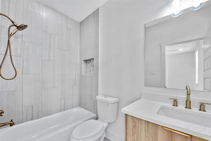 The third full bath has a tub and shower combination and is tiled all the way to the ceiling.