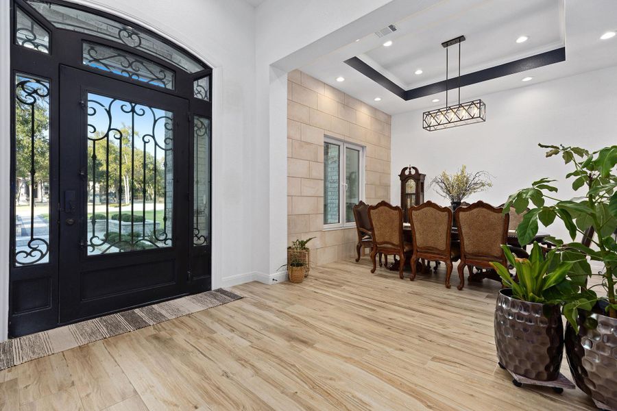 Entrance foyer featuring a tray ceiling, wood finished floors, and recessed lighting Entrance foyer featuring a tray ceiling, wood finished floors, and recessed lighting