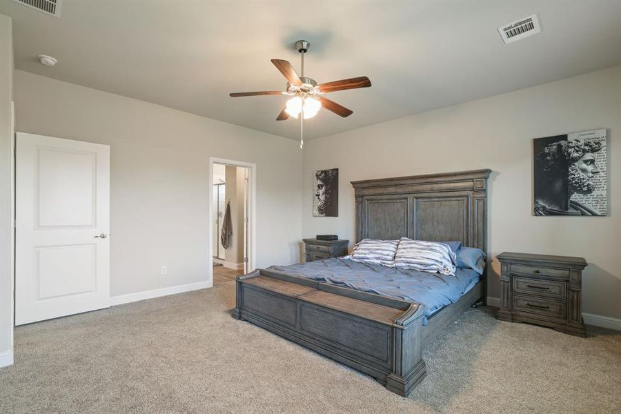 Bedroom featuring light carpet, ceiling fan, and connected bathroom Bedroom featuring light carpet, ceiling fan, and connected bathroom
