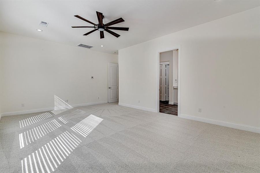 Carpeted spare room featuring ceiling fan