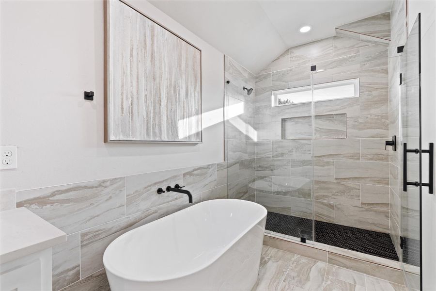 A stunning walk-in shower and freestanding soaking tub bring a high-end, resort-style feel right into your home. With beautiful tilework and an open, airy design, this bathroom is built for relaxation and comfort.