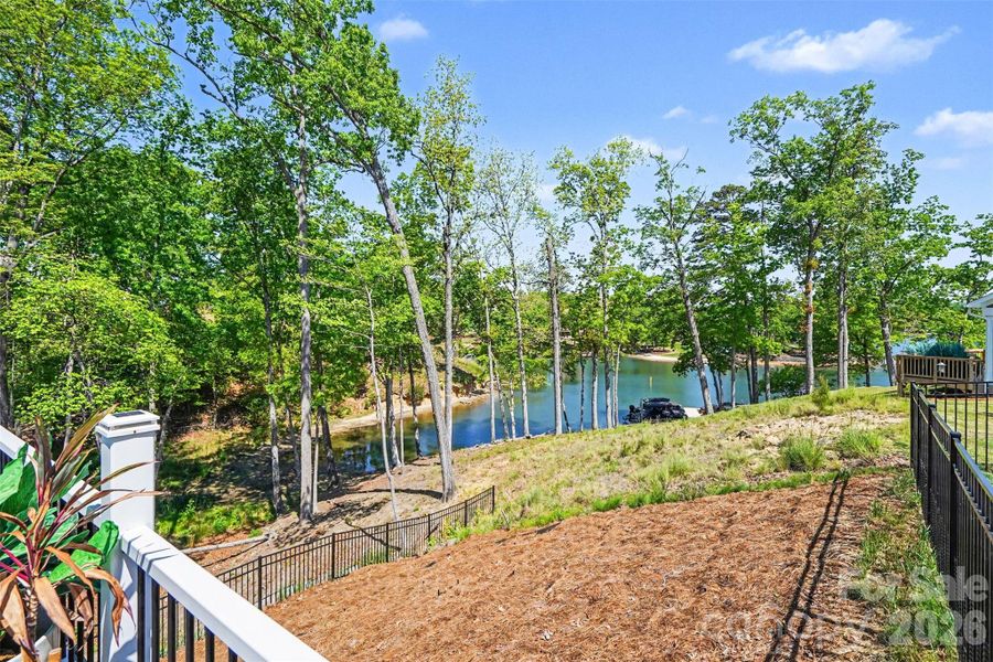 Scenic backyard with year-round water views, offering a peaceful, nature-filled setting surrounded by mature trees.