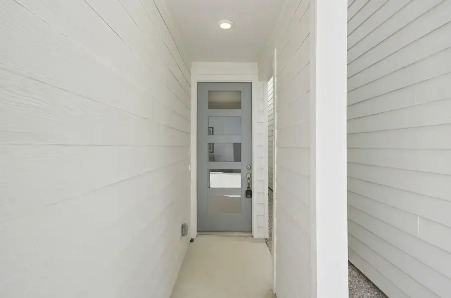 Modern front entry featuring a contemporary door with glass panels that allows natural light into the home. Modern front entry featuring a contemporary door with glass panels that allows natural light into the home.