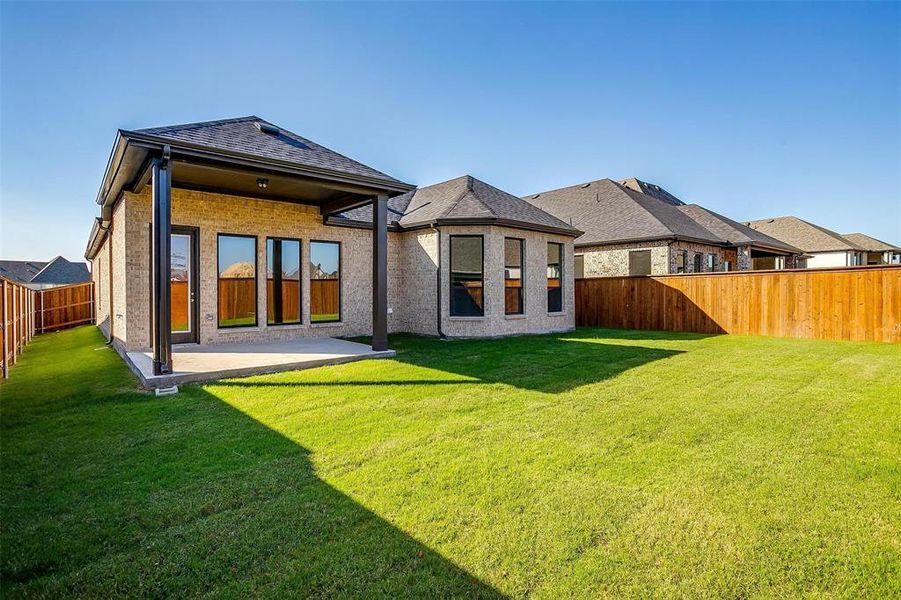 Rear view of property featuring a lawn