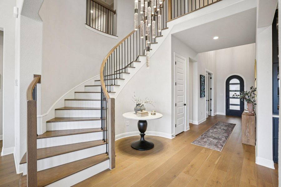 A beautifully designed staircase with iron railing leads to the second level, expanding the home's living potential.