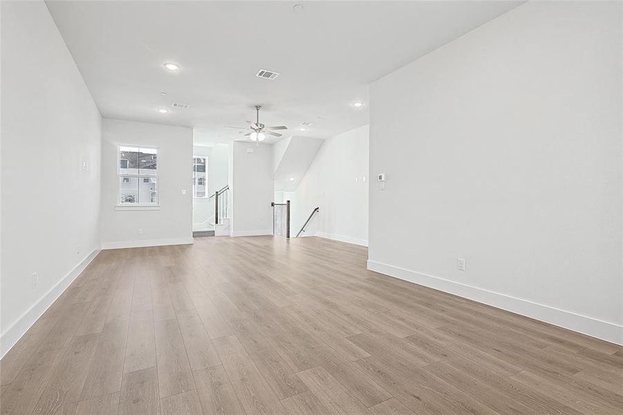 The property features light-colored plank flooring, recessed ceiling lights, and a ceiling fan with integrated lighting